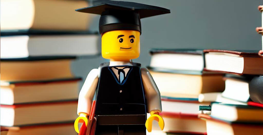 Eine Legofigur als Studiumabsolvent mit Graduation Cap (Mortarboard) umgeben von Büchern
